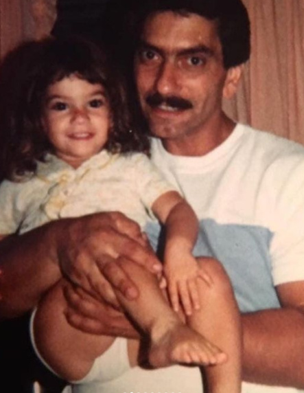 On the left side of the photo is Deena, and on the right side of the photo is Deena's Father, John, carrying Deena.